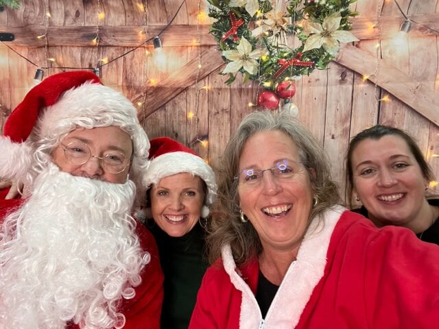 A group of people posing for a picture with santa claus.