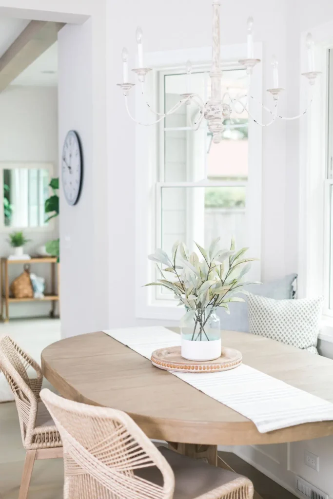 A dining room table with a vase of flowers on it.